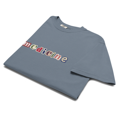 Blue t-shirt with colorful 'medicine' text on a white background